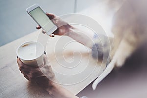 Woman holding hands smartphone and texting message.Female hands using mobile phone.Closeup on blurred background.Flares