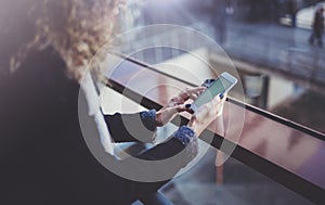 Woman holding hands smartphone and texting message.Female hands using mobile phone.Closeup on blurred background.Flares