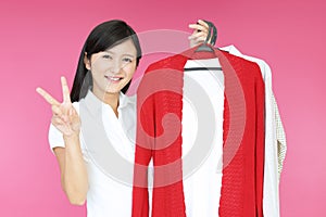 Woman holding hangers with trendy clothes