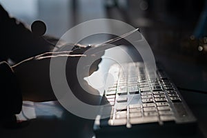 A woman is holding a headset with a microphone over a computer keyboard. Call center operator& x27;s workplace