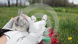 woman holding healthy Lovely bunny easter fluffy rabbits on green field. The Easter hares.