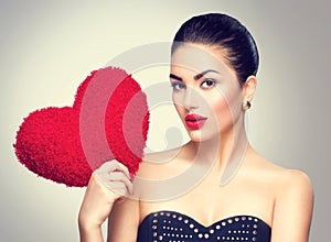 woman holding heart shaped red pillow