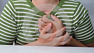 Woman holding her chest with pain expression.