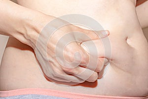 Woman holding her fat belly, stomach with hands, diet, weight loss and liposuction concept