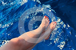 Woman holding her feet above the sea