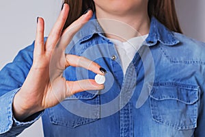 Woman holding in her hand one medical pill