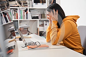 Woman holding her head with her arms and screaming