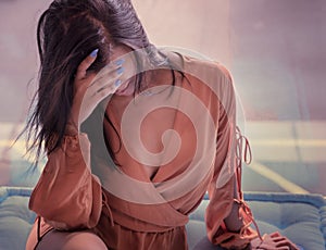 Woman holding her head down sad in deep thought