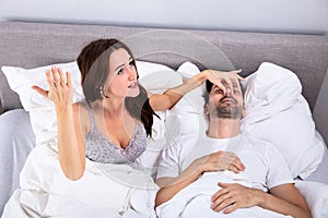 Woman holding her husband& 039;s nose to stop him from snoring