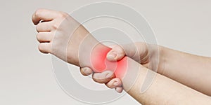Woman holding her inflamed wrist with red sore zone