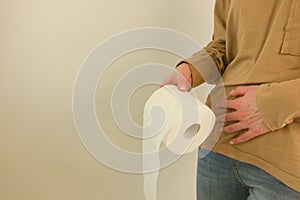 Woman holding her lower abdomen and toilet paper roll. Diarrhea, incontinence