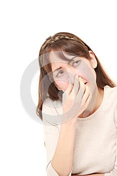 Woman holding her nose because of a bad smell