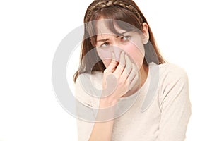 Woman holding her nose because of a bad smell