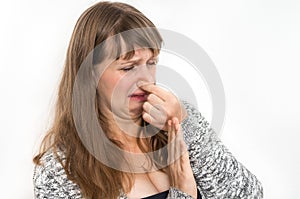 Woman is holding her nose - bad smell concept