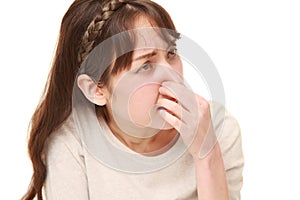 Woman holding her nose because of a bad smell