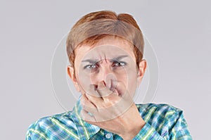 Woman holding her nose with her fingers