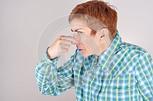 Woman holding her nose with her fingers