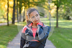 Woman holding her painful neck in park