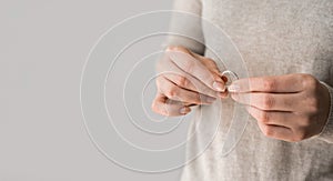 Woman holding her ring on a gray background