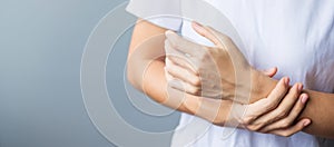 Woman holding her wrist pain because using smartphone or computer long time. De Quervain`s tenosynovitis, Intersection Symptom,