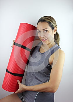 Woman holding her Yoga mat