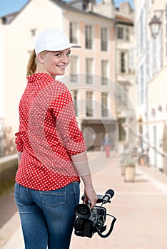 Woman holding his professional camcorder in the street