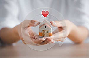 Woman holding home model on hands