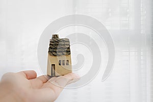 Woman holding home model on hands