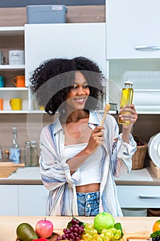 Woman holding honey bottle in kitchen room.