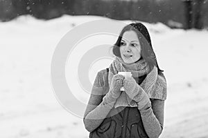 Woman holding hot drink outside