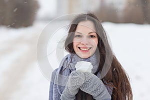 Woman holding hot drink outside