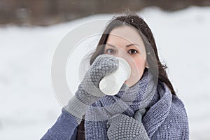 Woman holding hot drink outside