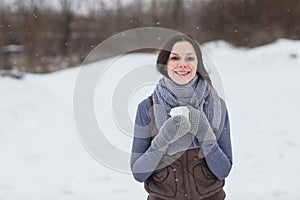 Woman holding hot drink outside