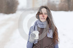 Woman holding hot drink outside