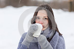 Woman holding hot drink outside