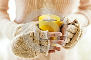 Woman holding hot steaming coffee cup close up photo