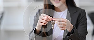 Woman holding house key in hand. Real estate mortgage.