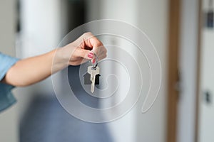 Woman holding house keys, hands close-up