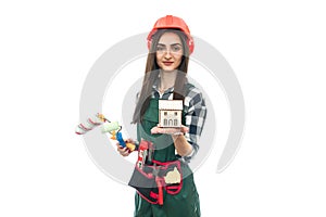 Woman holding house model and roller isolated on white