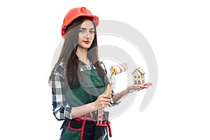 Woman holding house model and roller isolated on white