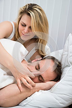 Woman is holding husband's nose