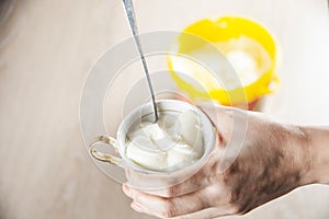 Woman holding ice cream bowl filled with ice cream and scoop in other hand