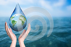 Woman holding icon of Earth in drop near ocean, closeup with space for text. Water save concept