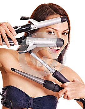 Woman holding iron curling hair.