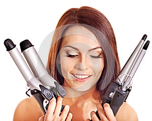 Woman holding iron curling hair.