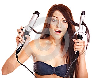 Woman holding iron curling hair.