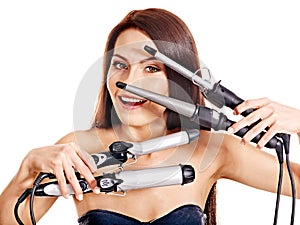 Woman holding iron curling hair.