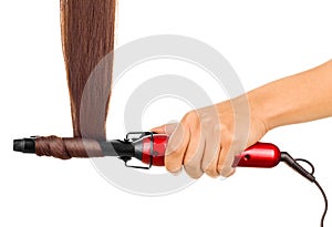 Woman holding iron curling hair.