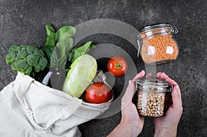 Woman holding jar of chickpeas. Vegetables in eco reusable bag. Eco friendly, zero waste concept