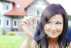 Woman holding keys with house background